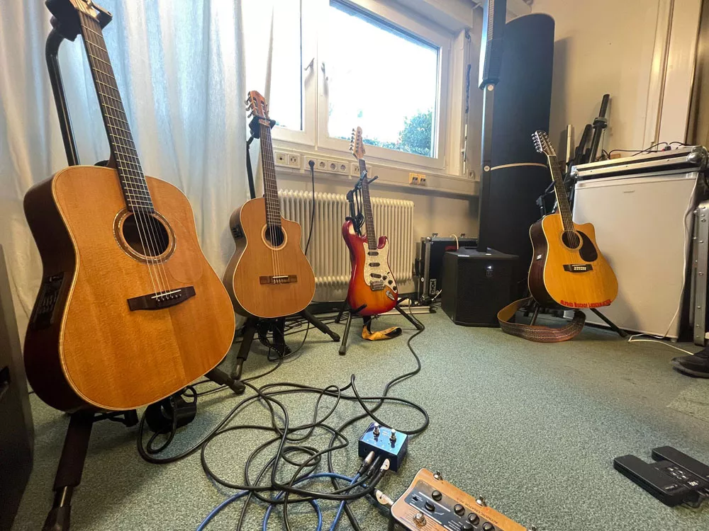 Gitarrensammlung von Alfred Bischof im Proberaum – mehrere Instrumente im Ständer vor der Studioausstattung. Gitarrensammlung von Alfred Bischof im Proberaum – mehrere Instrumente im Ständer vor der Studioausstattung.