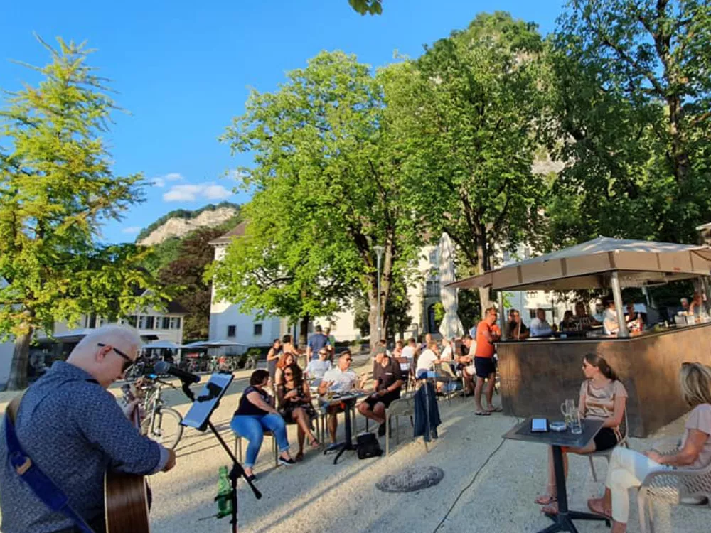 Musik für den guten Zweck: Blick über den Schlossplatz in Hohenems 2020 – Publikum auf Abstand, mobile Bar im Hintergrund, Alfred Bischof dezent am Bildrand – Straßenmusik trotz Pandemie. Musik für den guten Zweck: Blick über den Schlossplatz in Hohenems 2020 – Publikum auf Abstand, mobile Bar im Hintergrund, Alfred Bischof dezent am Bildrand – Straßenmusik trotz Pandemie.