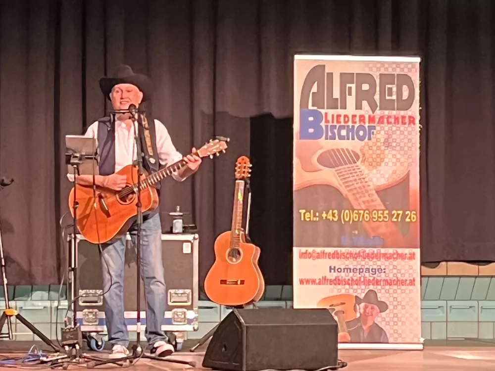 Alfred Bischof beim Konzert im Alten Hallenbad Feldkirch im Dezember 2024 – solo auf der Bühne mit Gitarre und schwarzem Hut, im Scheinwerferlicht. Alfred Bischof beim Konzert im Alten Hallenbad Feldkirch im Dezember 2024 – solo auf der Bühne mit Gitarre und schwarzem Hut, im Scheinwerferlicht.